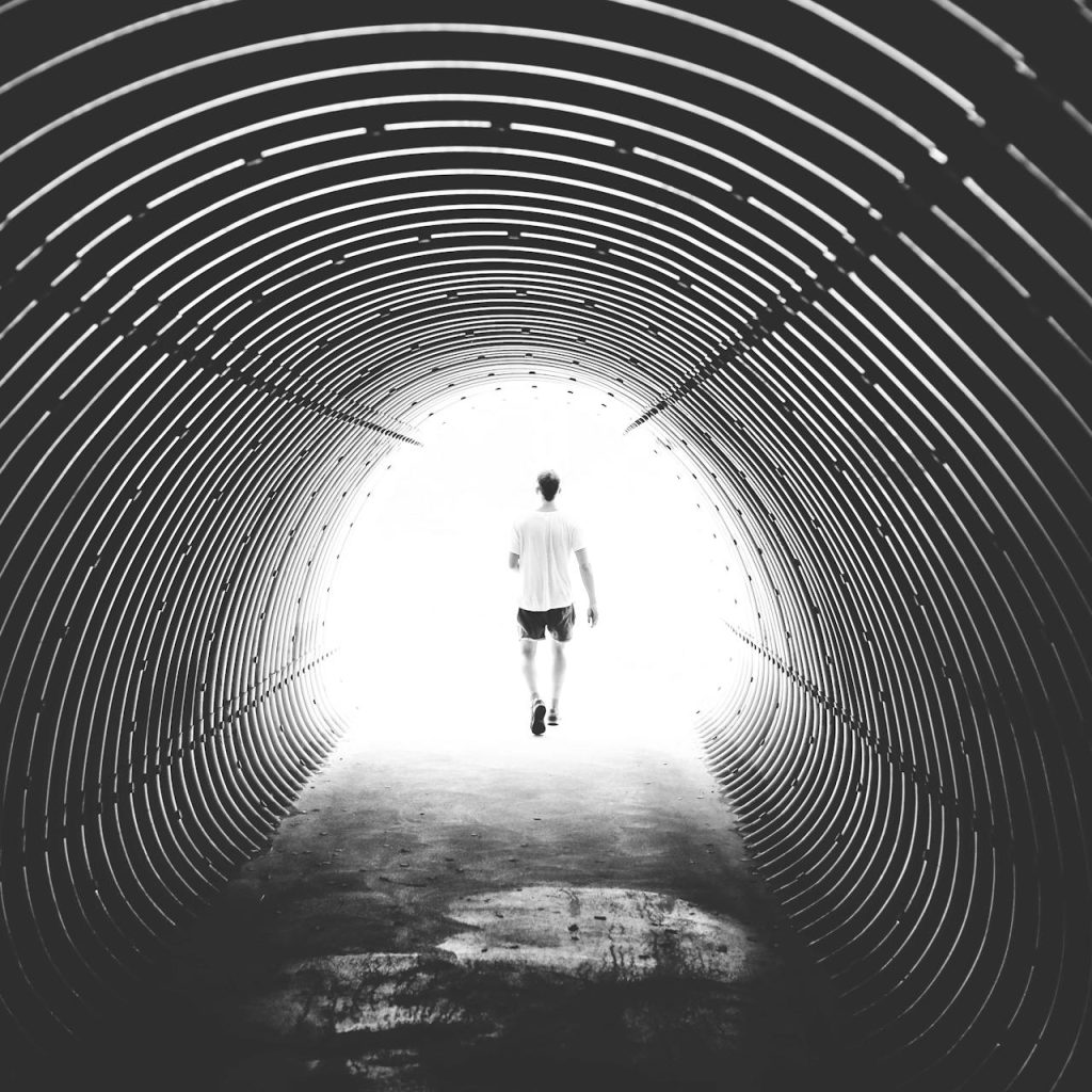 Neurodivergent man walking through a tunnel towards the light. Symbolizing a neurodivergent man seeking depression counselling in Kelowna.
